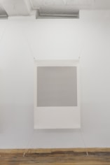 A photograph of one screenprint, stretched at all 4 corners. The center is grey and the framed around it is white. The work resembles a polaroid in it's arrangement.