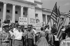 A group of people, several holding signs and American flags, protesting the admission of the &quot;Little Rock Nine&quot; to Central High School, Little Rock, Arkansas, 1959 (Courtesy Library of Congress).