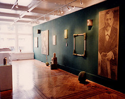 Blue painted gallery wall, with large portraits and wooden frames