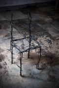 Michele Oka Doner's Terrible Chair, full diagonal view from above in a darker warehouse setting