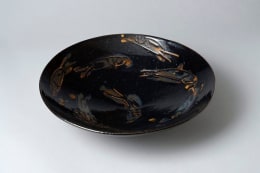 Persimmon on black-glazed large shallow bowl with dog-like animal patterning