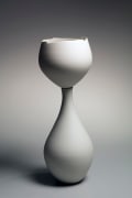Tall two-part sculpture of white round bowl supported by separate vase-like base