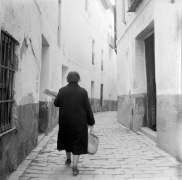 Woman walking with basket from behind, Sevilla, Spain, November, 1956