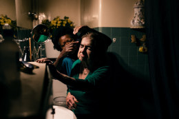 Ana Maria Jeremias cleaning and caring for the elderly lady she works for, after helping her up from a fall. Lisbon, Portugal, 2024