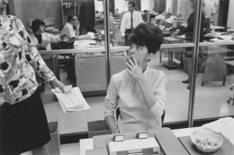Secretary smoking at her desk, Detroit, 1968