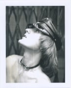 Nude white male in profile from the chest up, wearing leather hat and choker.