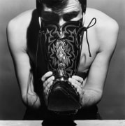 Manputting his face into boot.
