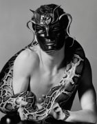 Man wearing mask, holding snake.