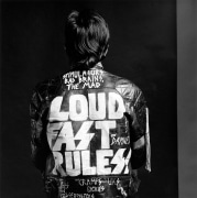Nick Marden facing away from camera wearing leather jacket with text &quot;Loud, Fast, Rules&quot;.