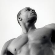 View of a shirtless man from below, looking to his left.