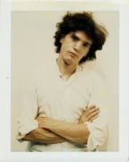Self-Portrait polaroid of the artist with arms folded.