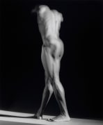 A nude male photographed from behind. His head is bowed and not visible