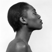 Profile view of a Black woman, hair slicked back, chin tilted up.