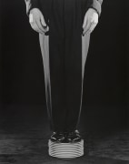 Person in suit standing on stack of plates.