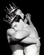 Two shirtless white men dancing, wearing crowns.