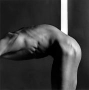 Nude black man bending forward with head out of frame.