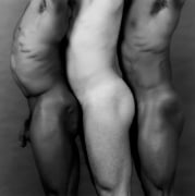 Three nude figures stand back to front facing towards the left.