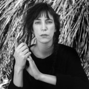 Portrait of Patti Smith, hands grasped.