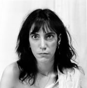Patti Smith with eyes crossed, shirt falling off one shoulder.