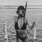 Lisa Lyon climbing up a ladder from the water wearing a bathing suit and snorkles.