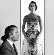 Model Dovanna facing camera in dress at center, Karl Lagerfeld wearing suit in profile at left.