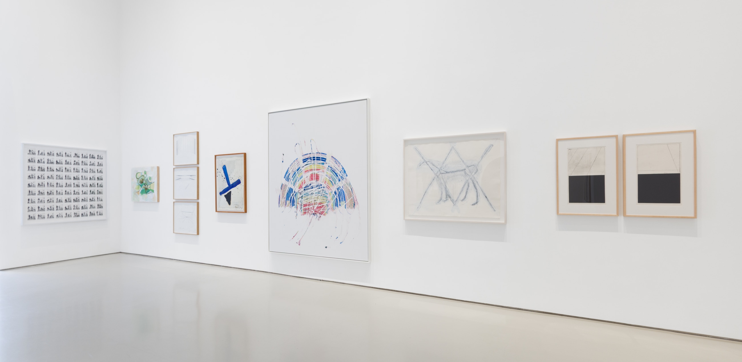 corner of gallery pictured with framed artworks of various sizes on the wall