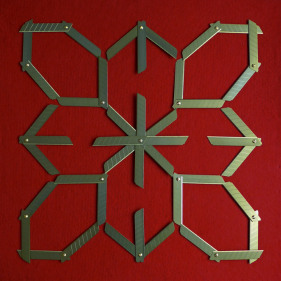 Abdullah M. I. Syed  Margin of Error - Rosette on Red, 2017  Titanium utility knife blades, brass, stainless steel, felt and tempered hardwood  23 x 23 in