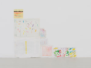 An installation of varied pieces of white paper with multicolored markers