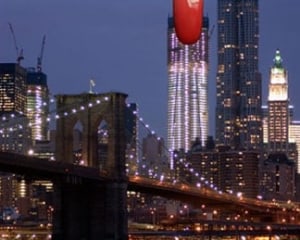 An image of the New York City Skyline from Brooklyn looking at the Brooklyn Bridge toward Manhattan, with a red fingernail at the top of one building