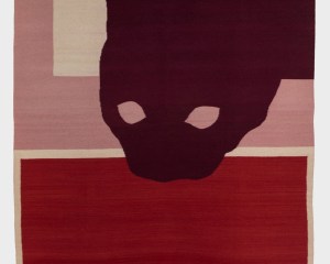 A vertically-oriented textile work with a silhouette of a cat peaking into the center from the top-right corner. The bottom half of the rug is crimson, with a beige border. The upper half is beige with a thick pink border on the left and bottom of the rectangle.