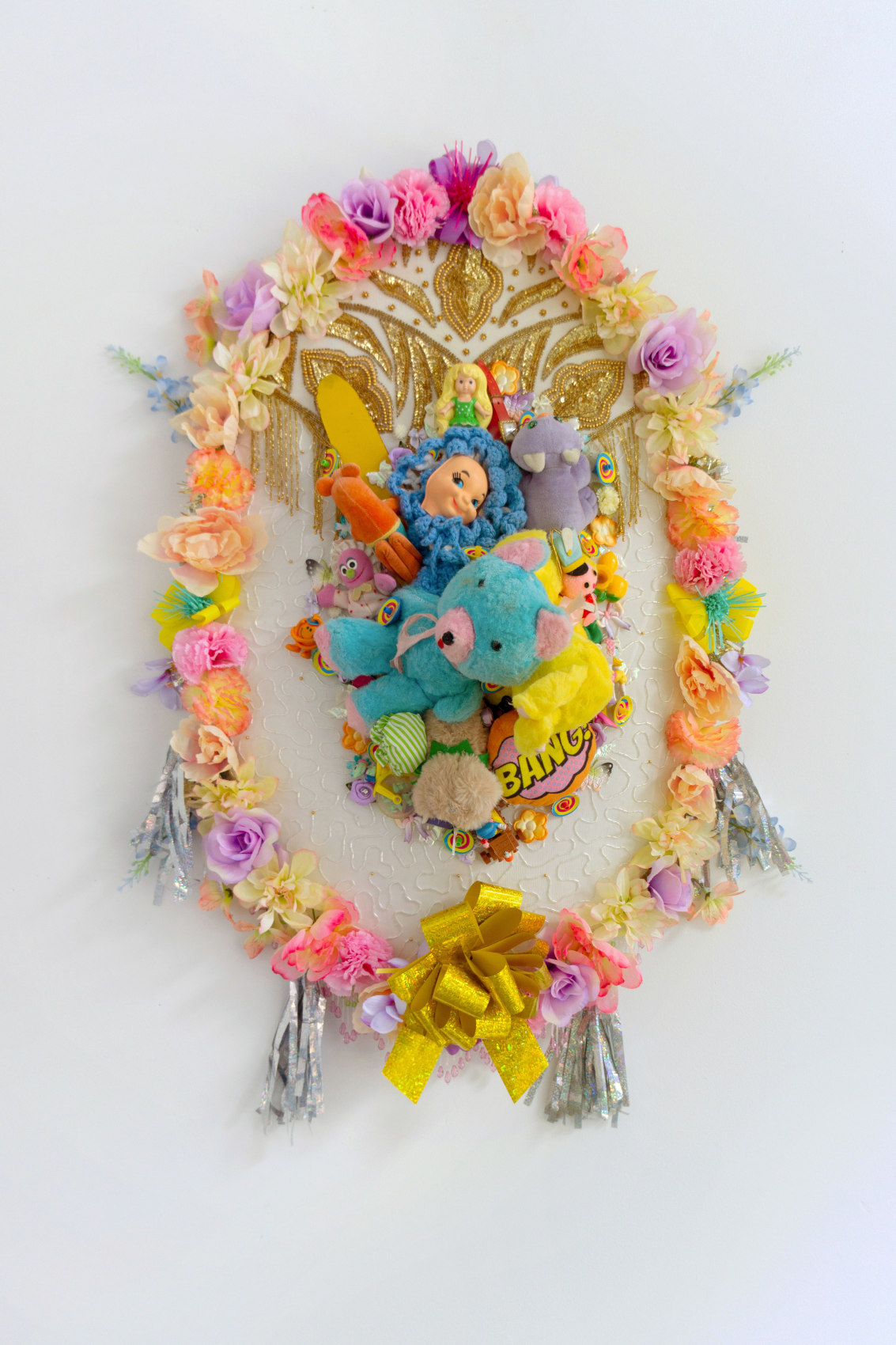 Max Colby,&nbsp;Elegy 16, 2020,&nbsp;Found fabric, trim, fabric flowers, magnets, ribbon, patches, toys, garland, polyester&nbsp;batting, MDF,&nbsp; thread,&nbsp;44 x 30 x 15 in (111.76 x 76.2 x 38.1 cm)