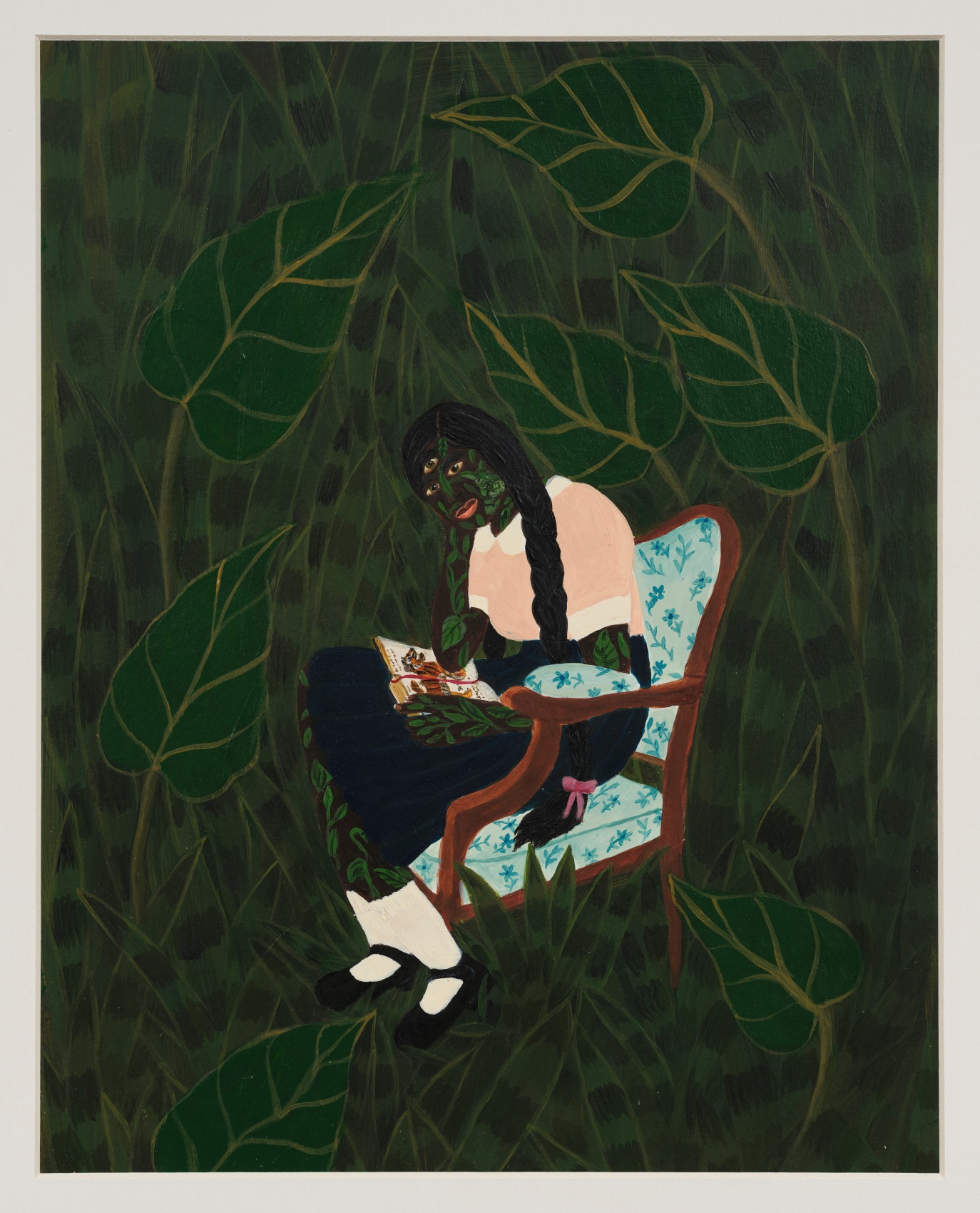 Sanbras sitting on a chair reading a book