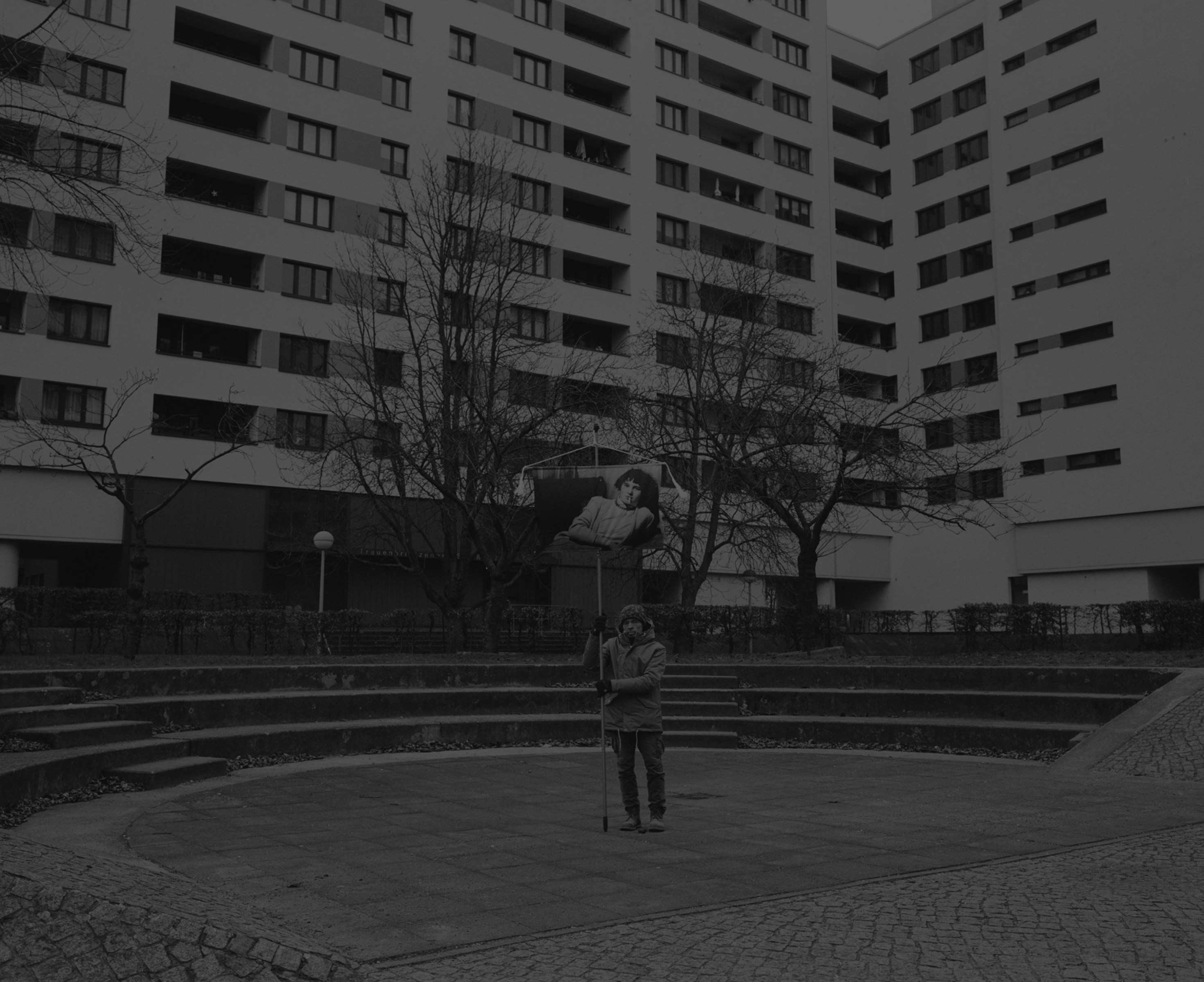 Daniel Joseph Martinez The inner yard of Märkisches Viertel. The Märkisches Viertel consists of a large housing estate of about 17,000 apartments with chains of high-rises up to 18 floors that were built from 1964 to 1974. To the east it shares its border with the Rosenthal and Wilhelmsruh localities of the Pankow borough, from which it was separated by the Berlin Wall until 1989. In 2003 Märkisches Viertel had about 36,000 inhabitants., 2017 Medium format black & white film printed digitally on Hahnemule Fine Art Baryta, Gloss 315gsm 60 x 72 in (152.4 x 182.88 cm)