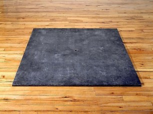 black square sculpture on a hardwood floor