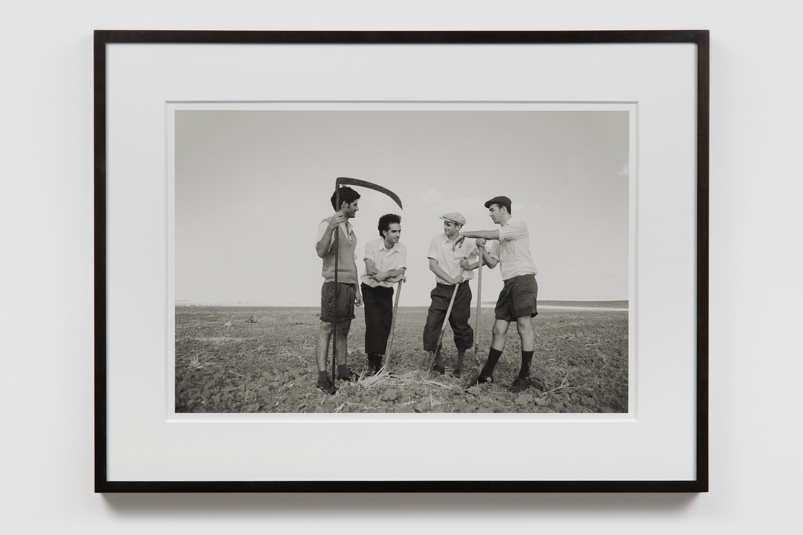 a group of four holding scythes