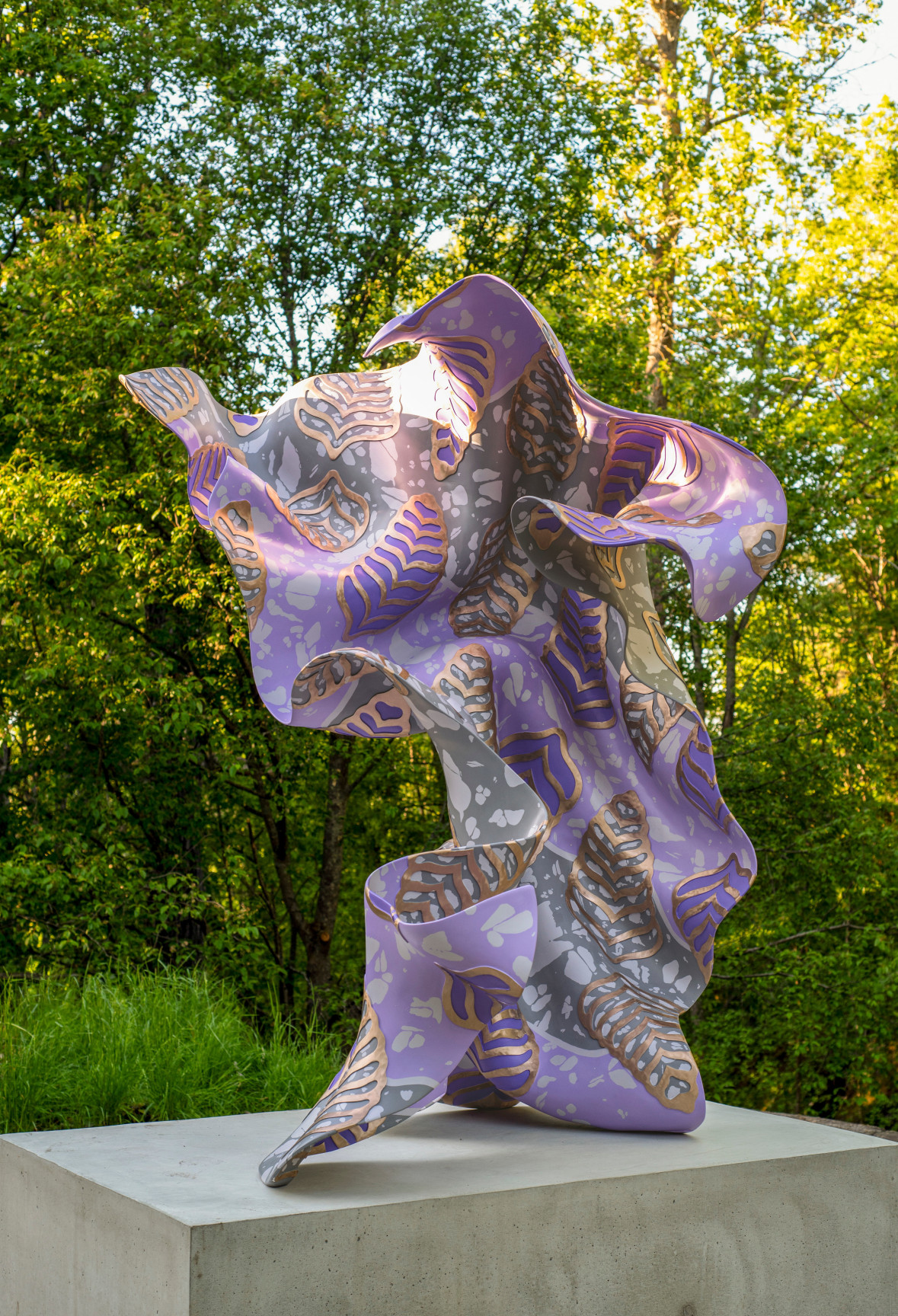 A large, purple, bronze, gestural sculpture sitting atop a rectangular base
