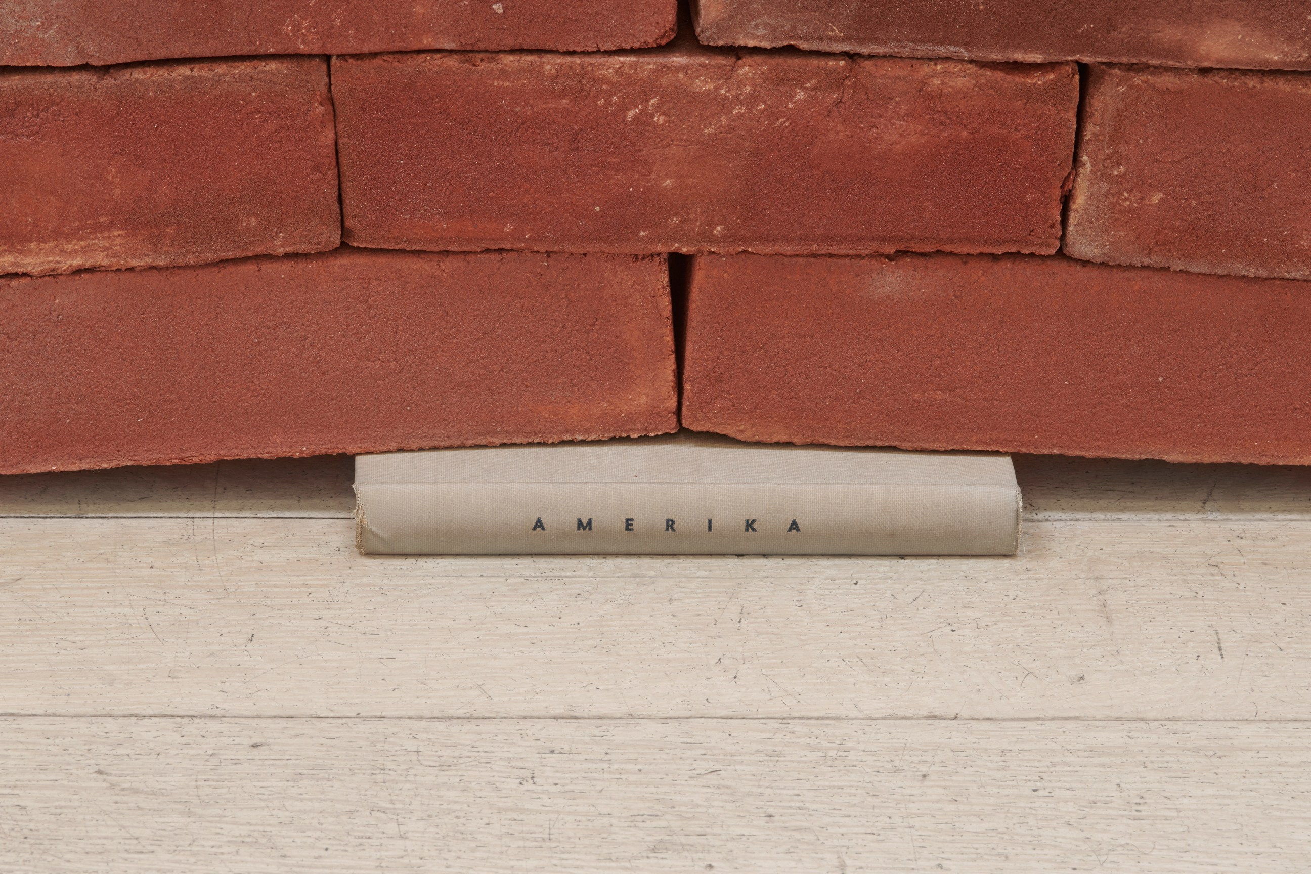 book under a brick wall