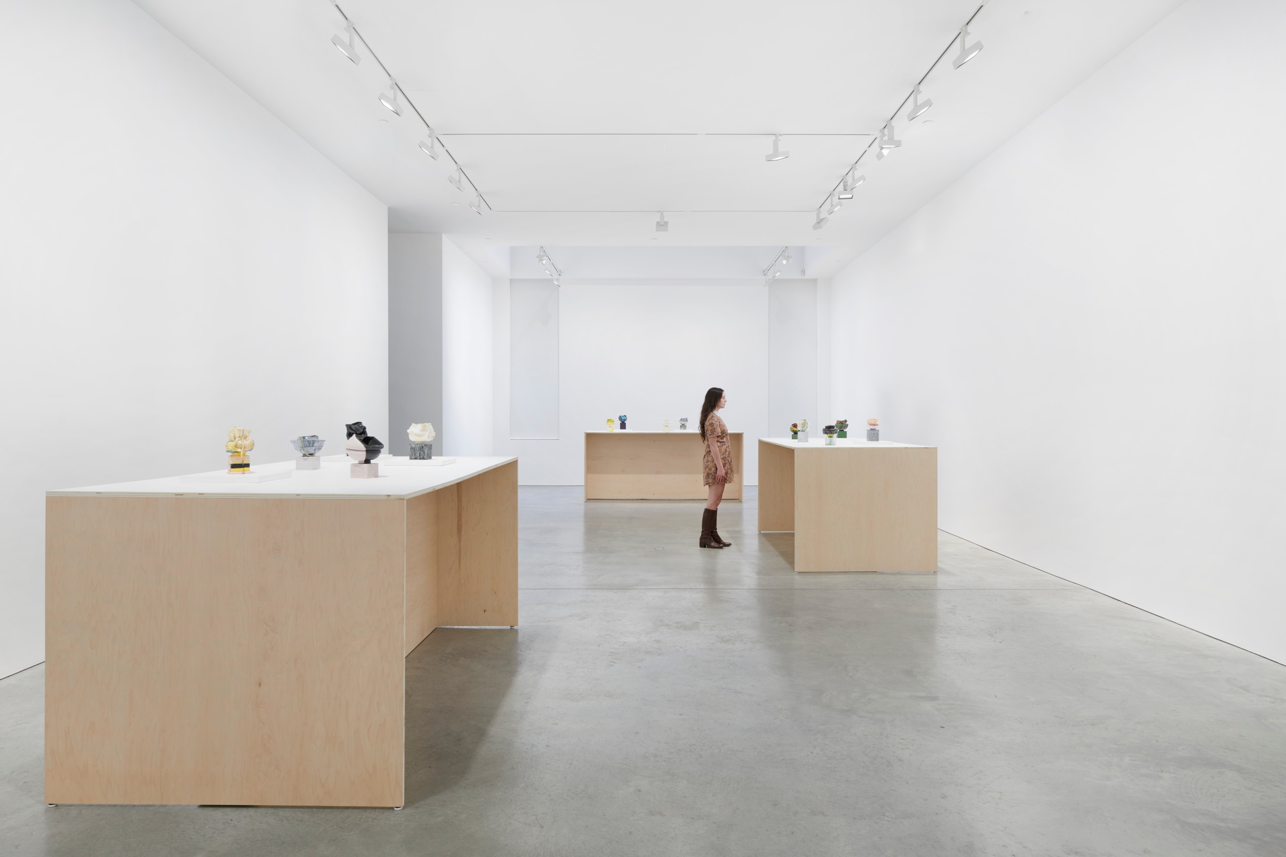 person looking at one of the tables of small artworks