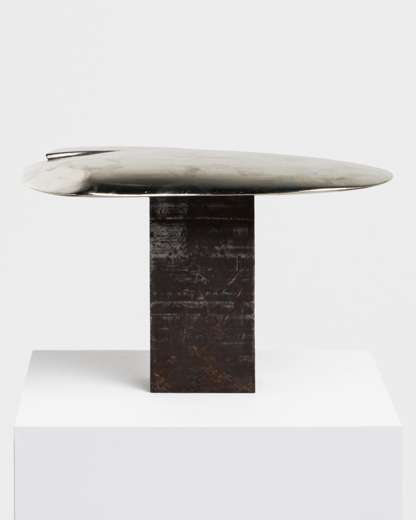 black rectangular block balancing a metal disk