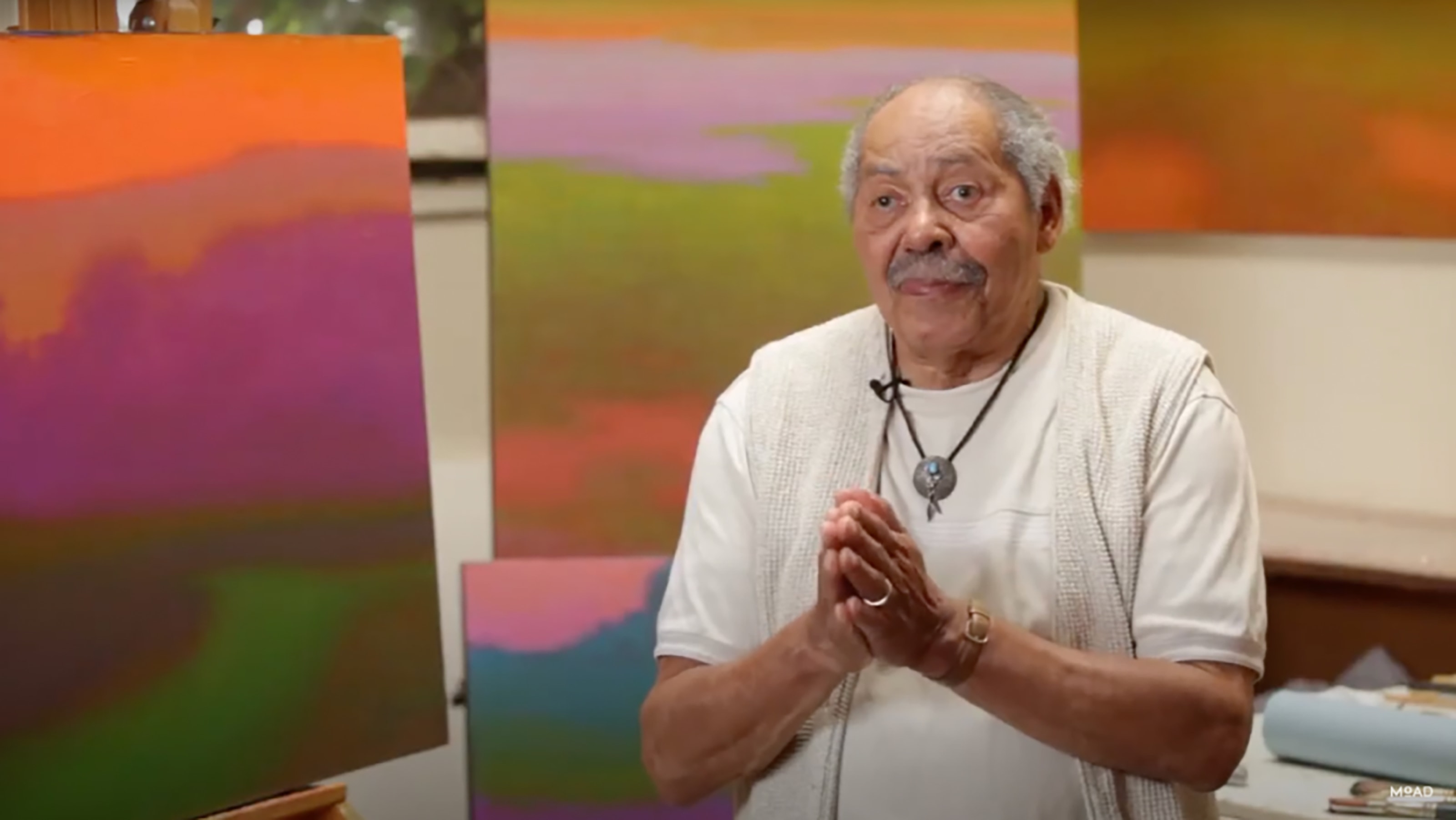Richard Mayhew with his paintings in his studio