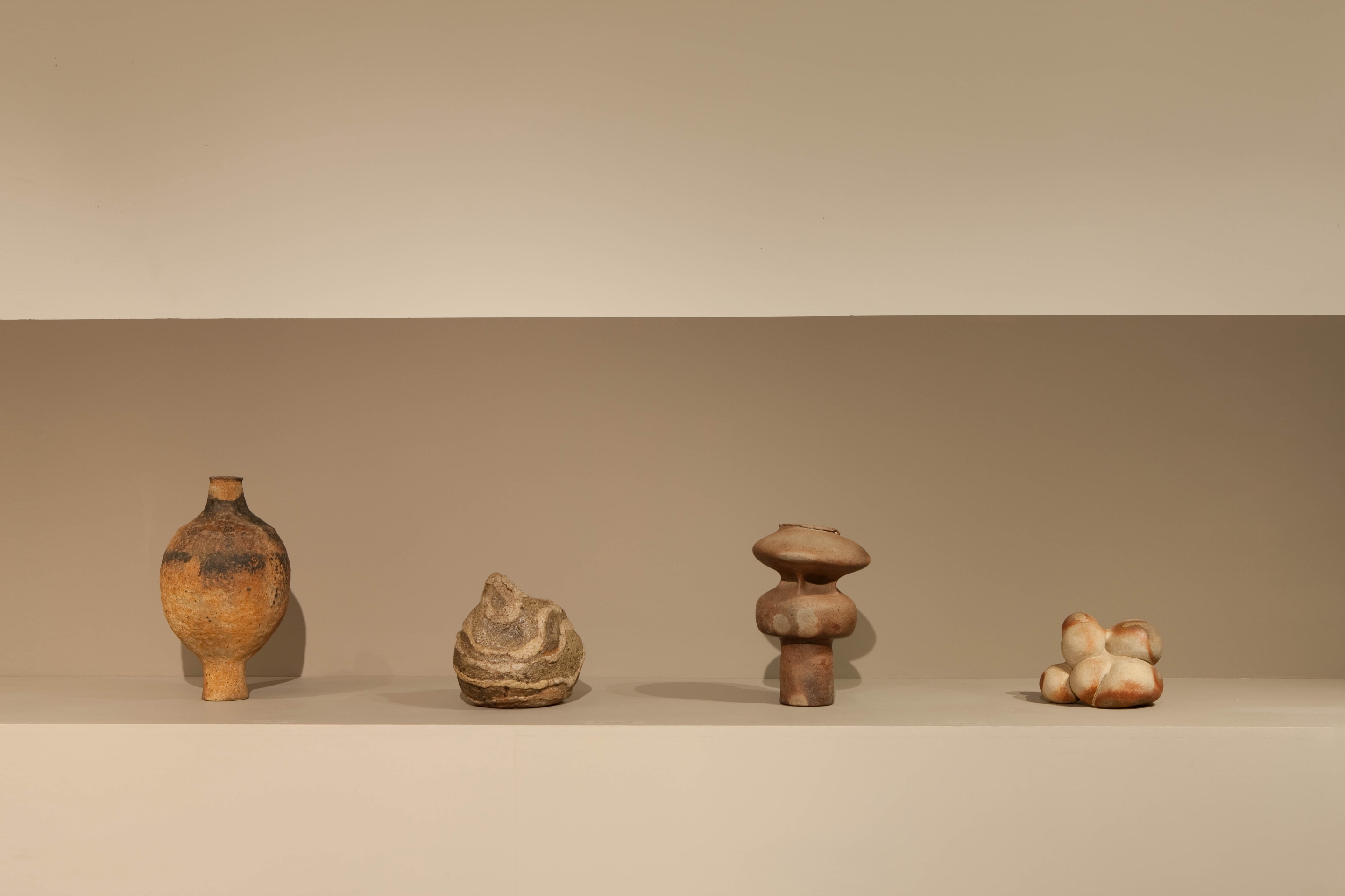 Lined up view of ceramic pieces from left to right: Jean and Jaqueline Lerat's large ceramic vase (c. 1960), Hildegund Schlichenmaier's sculptural vase (c. 1966-68), Elisabeth Joulia's large vase (c. 1960), and Elisabeth Joulia's sculpture (c. 1982)