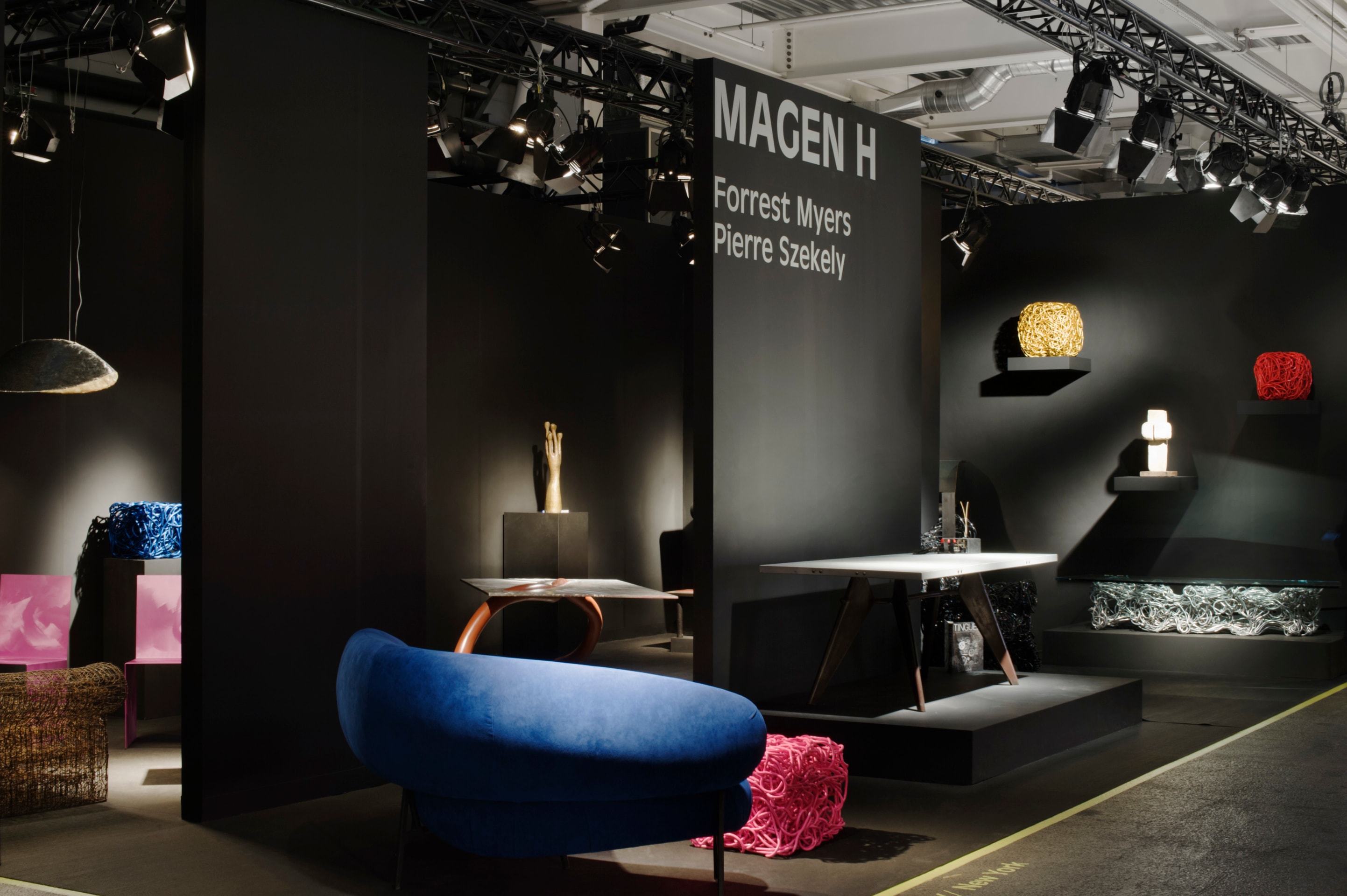 Magen H Gallery's booth at Design Miami/ Basel, installation view of entire booth, showing Pierre Sz&eacute;kely's boomerang shaped sofa, Forrest Myers' Pink Tuffitt, Jean Prouv&eacute;'s dining table, Forrest Myers' &quot;Sea Change&quot; coffee table, &quot;Gilder&quot; sculpture, and Red Tuffitt