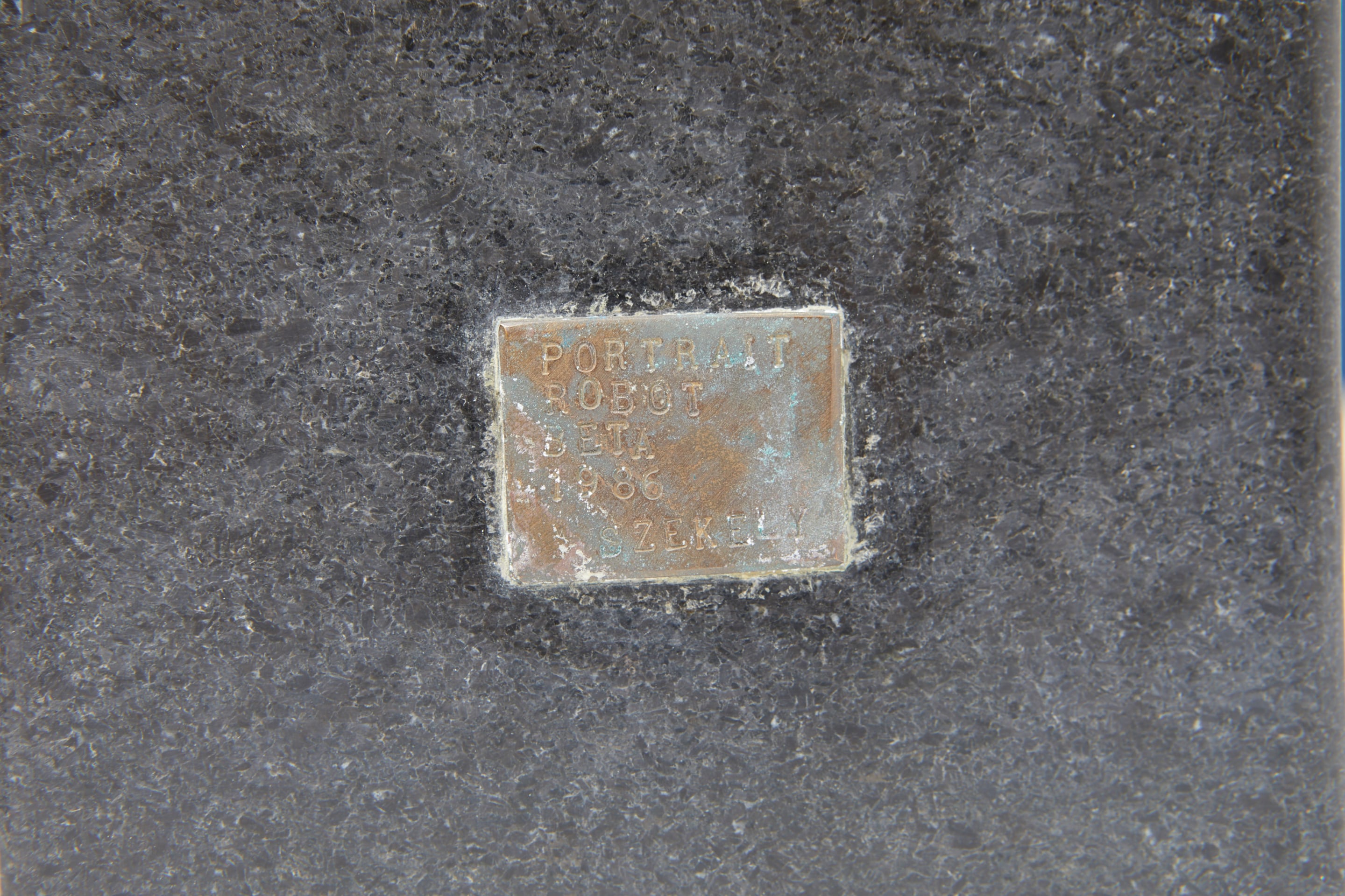 Pierre Székely's &quot;Portrait Robot Alpha et Beta&quot; sculpture, detailed view of metal plate with title, date and signature