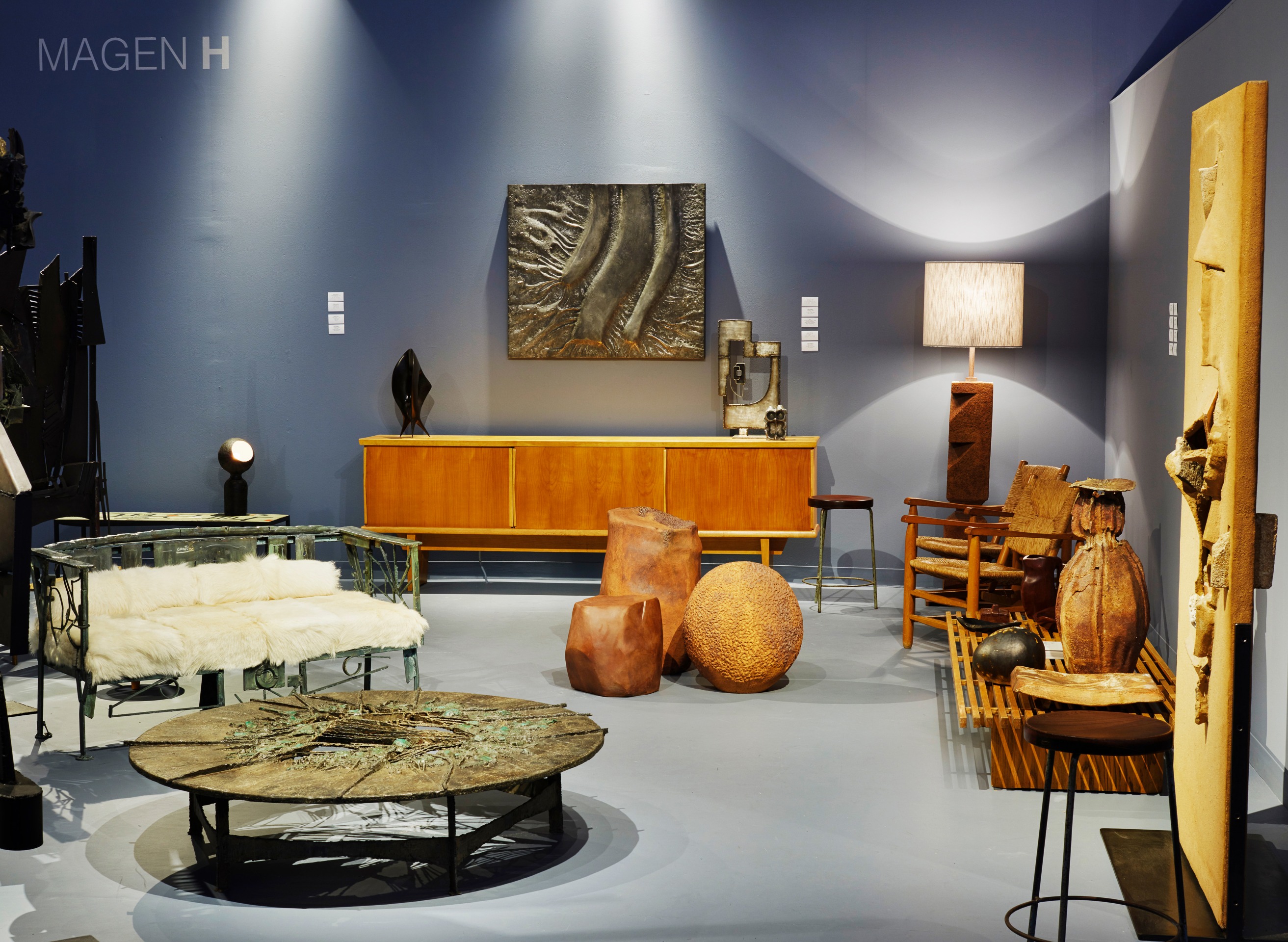 Magen H Gallery's booth at Design Miami, install image of half the booth with Sylvain Contini's sculptural bench, Pia Manu's malachite circular coffee table, Charlotte Perriand's sideboard, Annie Fourmanoir's ceramic stools, Gustave Tiffoche's floor lamp