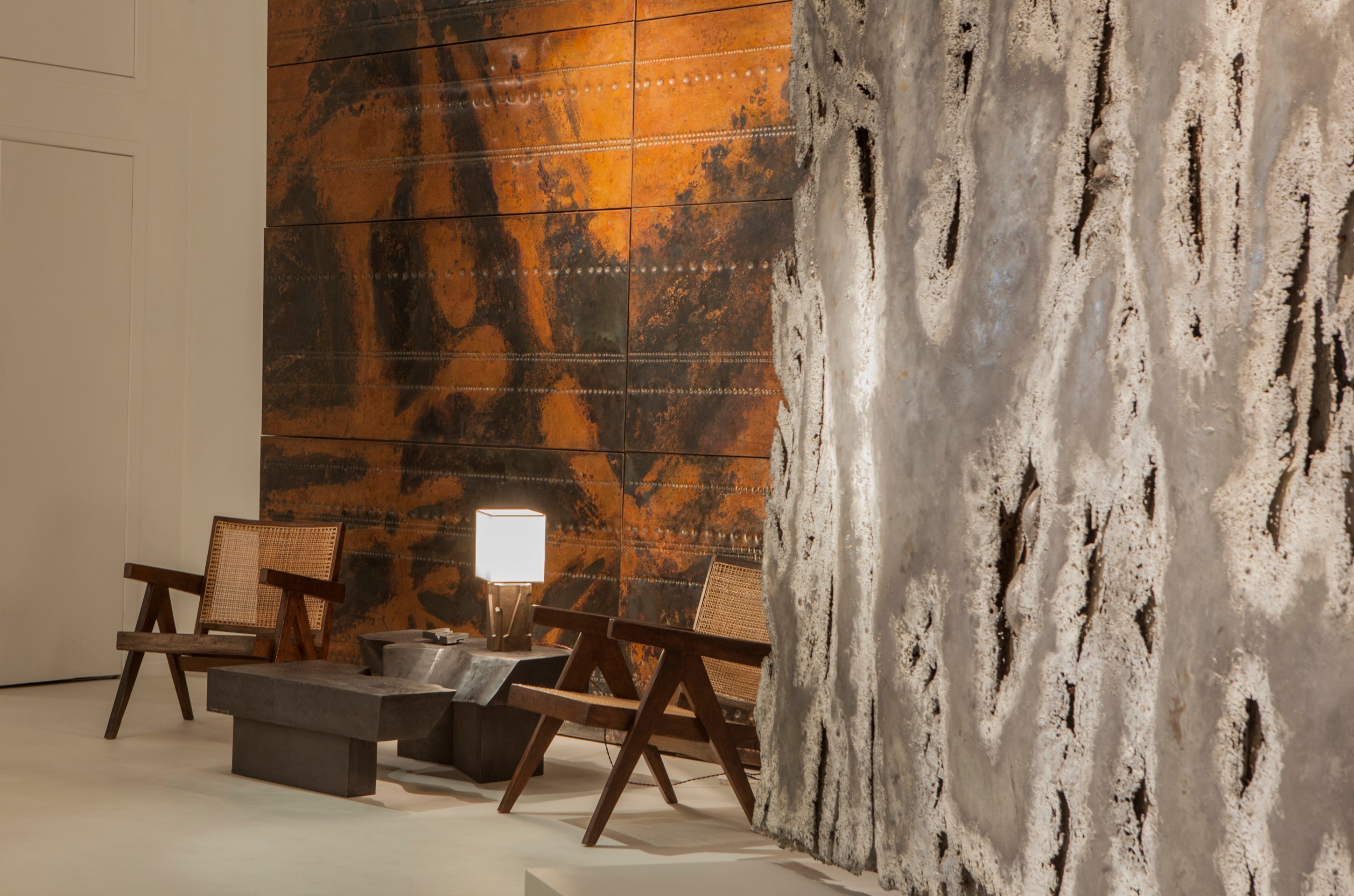 Pierre Sabatier exhibition installation view: displaying Pierre Jeanneret's pair of easy armchairs, Sabatier's &quot;San Andreas&quot; coffee table and &quot;Beauvais I&quot; table lamp next to &quot;Passage II&quot; sculptural claustra