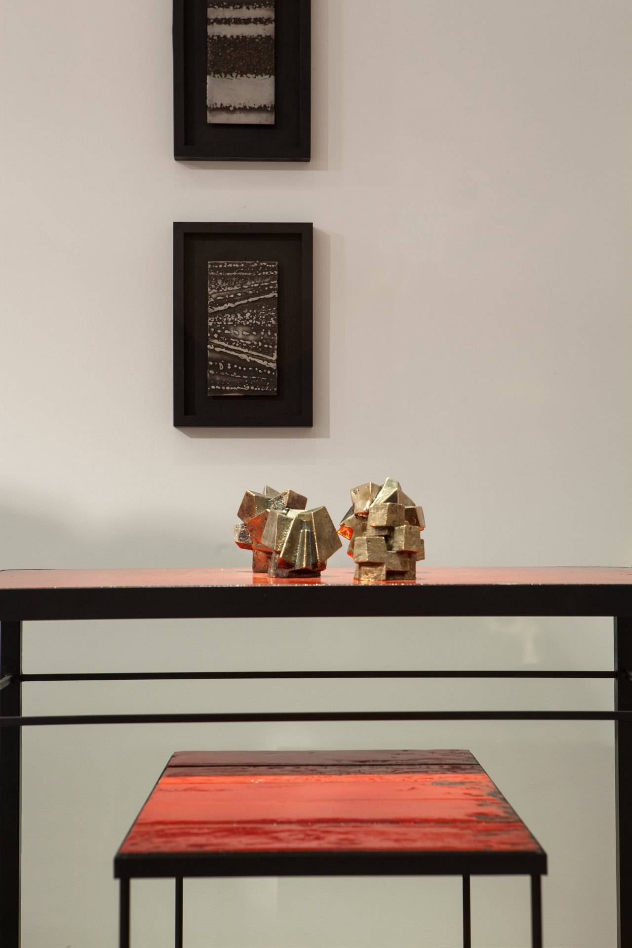 Pierre Sabatier exhibition close up installation view: displaying wall sculptures, two &quot;Charbonnite&quot; sculptures on top of &quot;Volvic Rouge III&quot; dining table and &quot;Volvic Sang&quot; side table