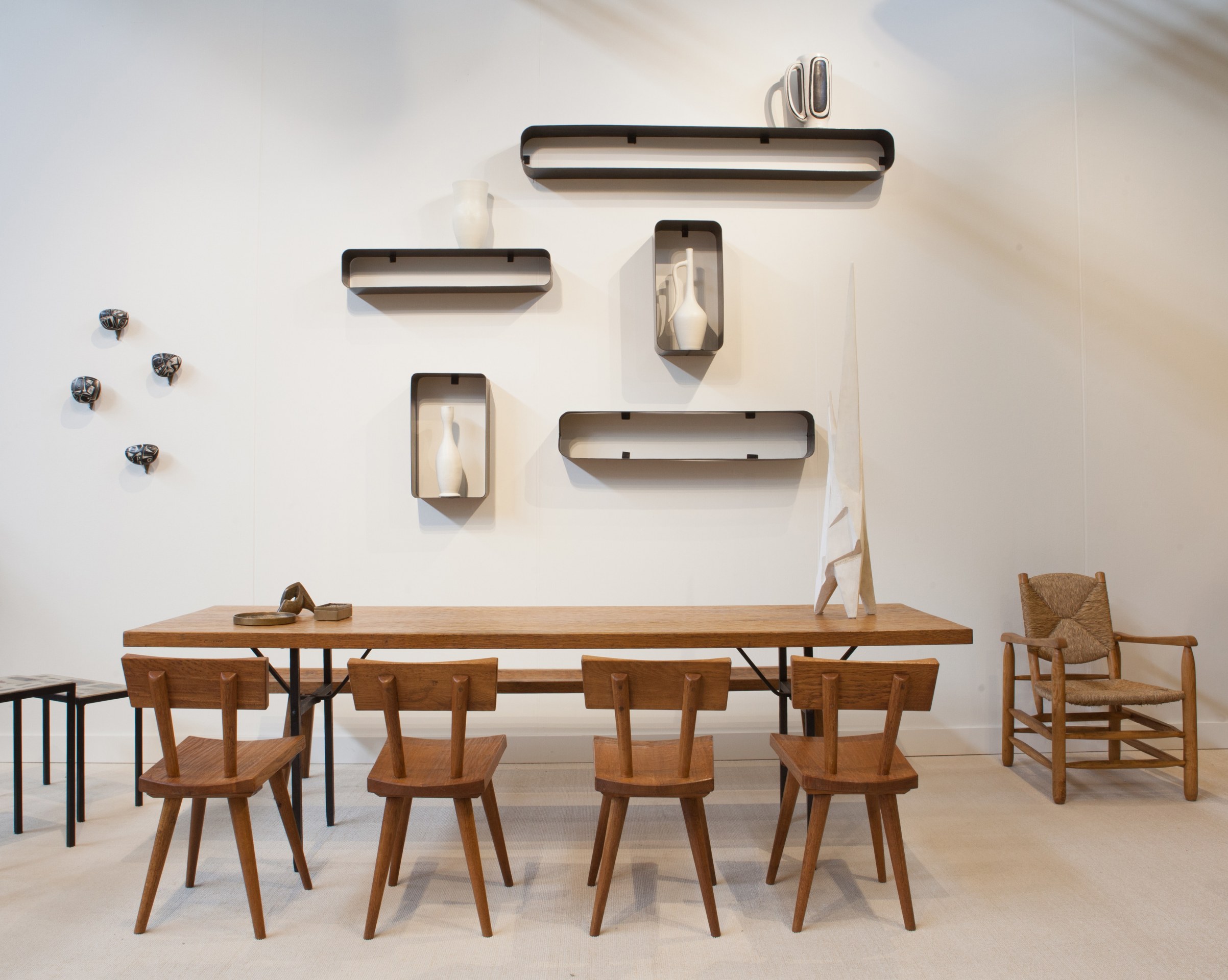 Magen H Gallery's booth at FOG Design + Art, pieces from left to right are Victor Cerrato's set of 4 ceramic hooks, Marolles dining table and set of 4 chairs, Alain Douillard's set of 5 shelves, Andr&eacute; Bizette-Lindet's sculpture and Charlotte Perriand's armchair