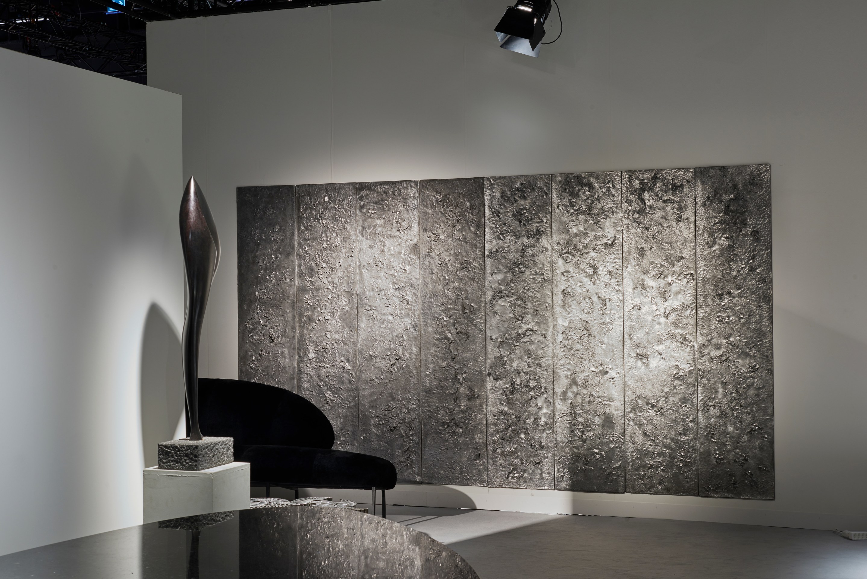 Magen H Gallery's booth at Design Miami/Basel, installation view showing a corner of Pierre Sz&eacute;kely's boomerang shaped sofa and Luiza Miller's set of eight panels