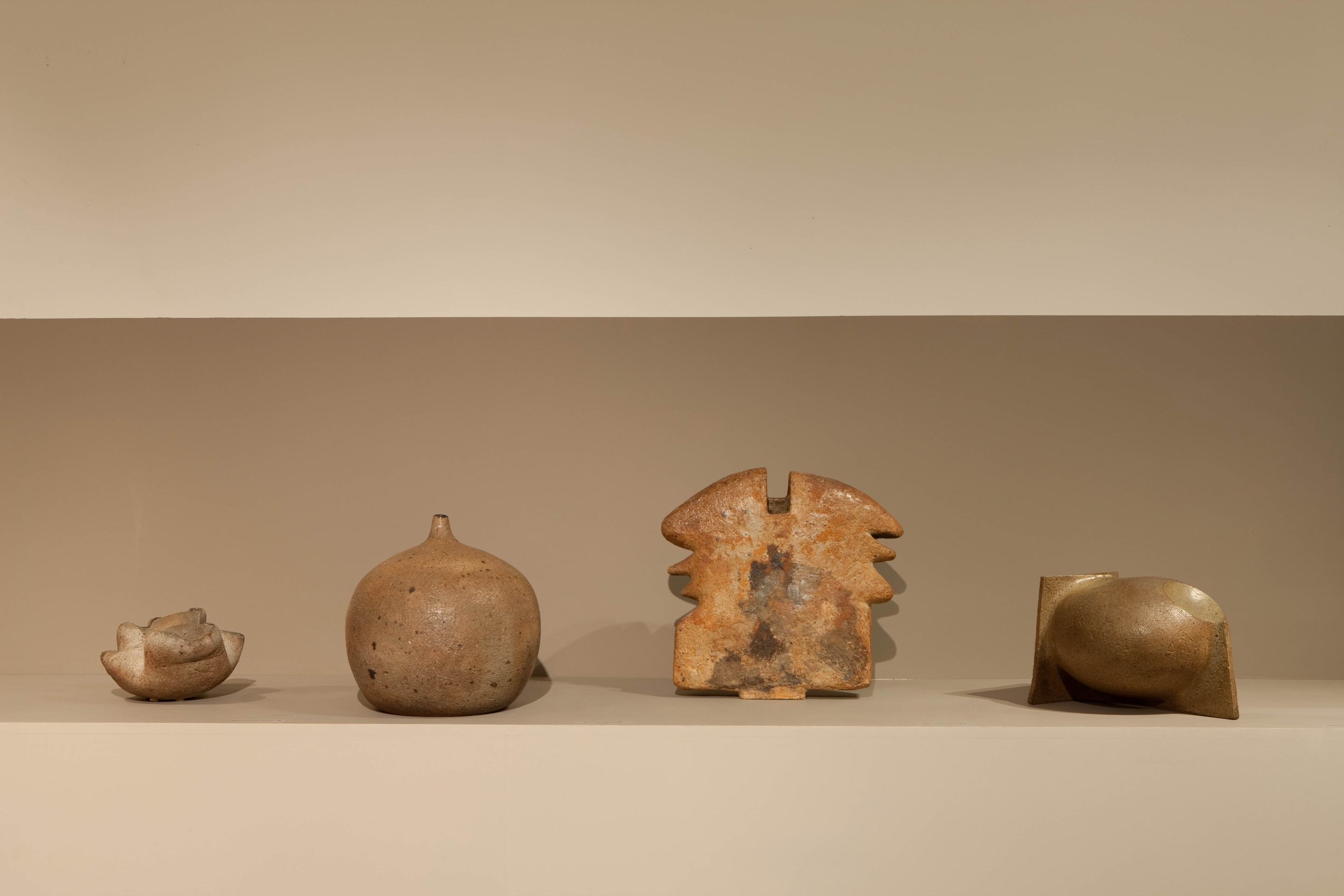 Lined up view of ceramic pieces from left to right: Elisabeth Joulia's ceramic sculpture (c. 1982), Elisabeth Joulia's ceramic round vase (c. 1960-62), Jean and Jaqueline Lerat's ceramic vase (c. 1969), and Robert Deblander's ceramic sculpture (c. 1960)