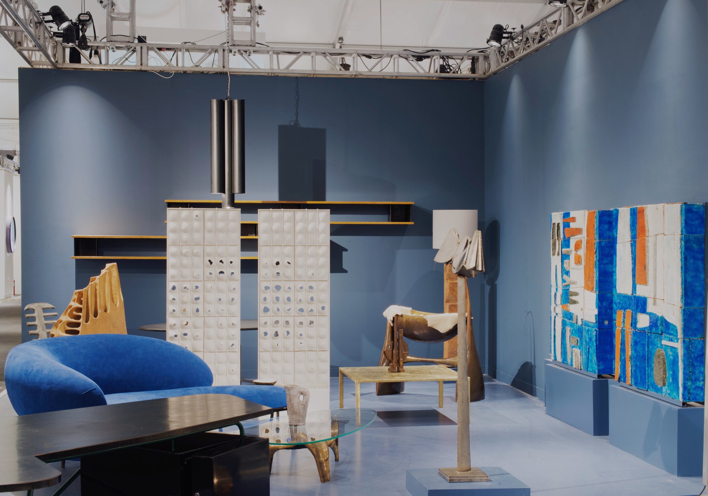 Magen H Gallery's booth at Design Miami/, side view of booth showing Pierre Sz&eacute;kely's boomerang shaped sofa, Philolaos Tloupas' sculpture psych&eacute;, and Jean Amado's ceramic mural